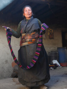 Woman at Dzong in the Mustang region of Nepal showing off her weaving